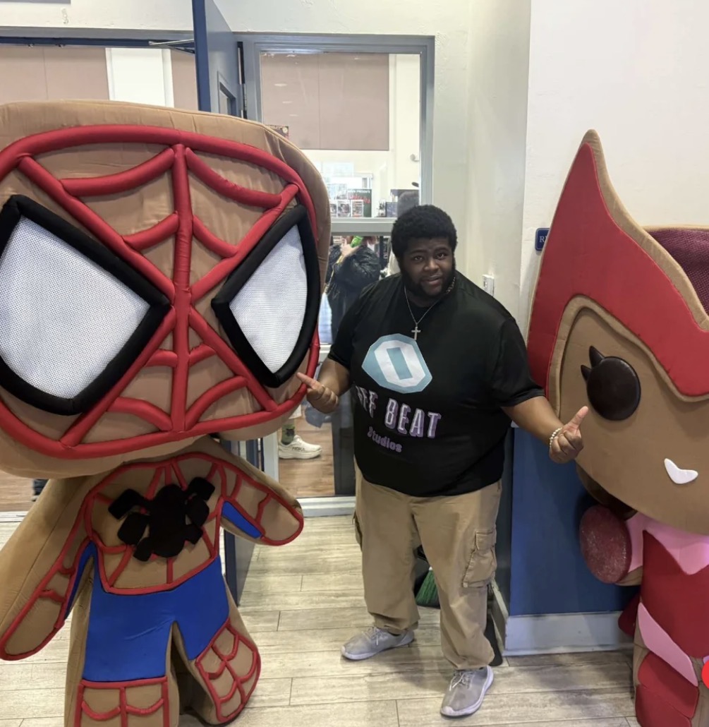 Fan posing with large character displays at a past Charlie’s event